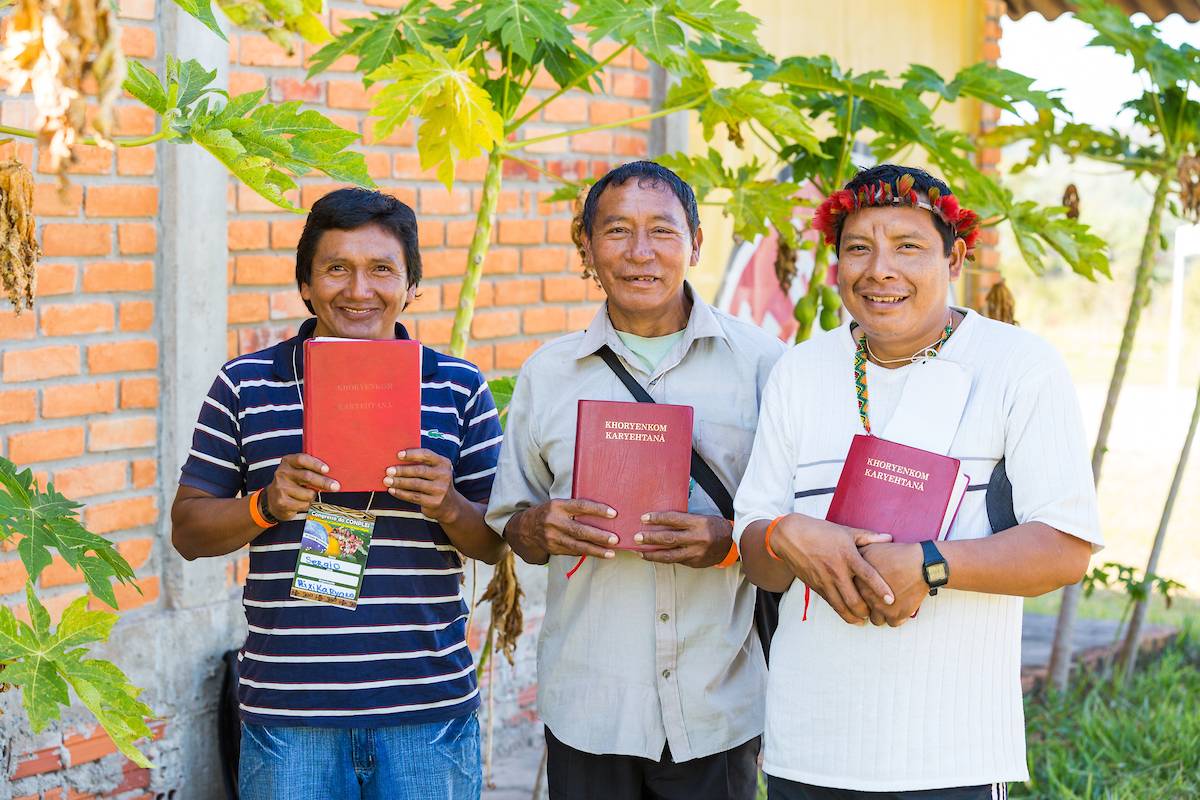 Three men holding Bibles in Brazil.